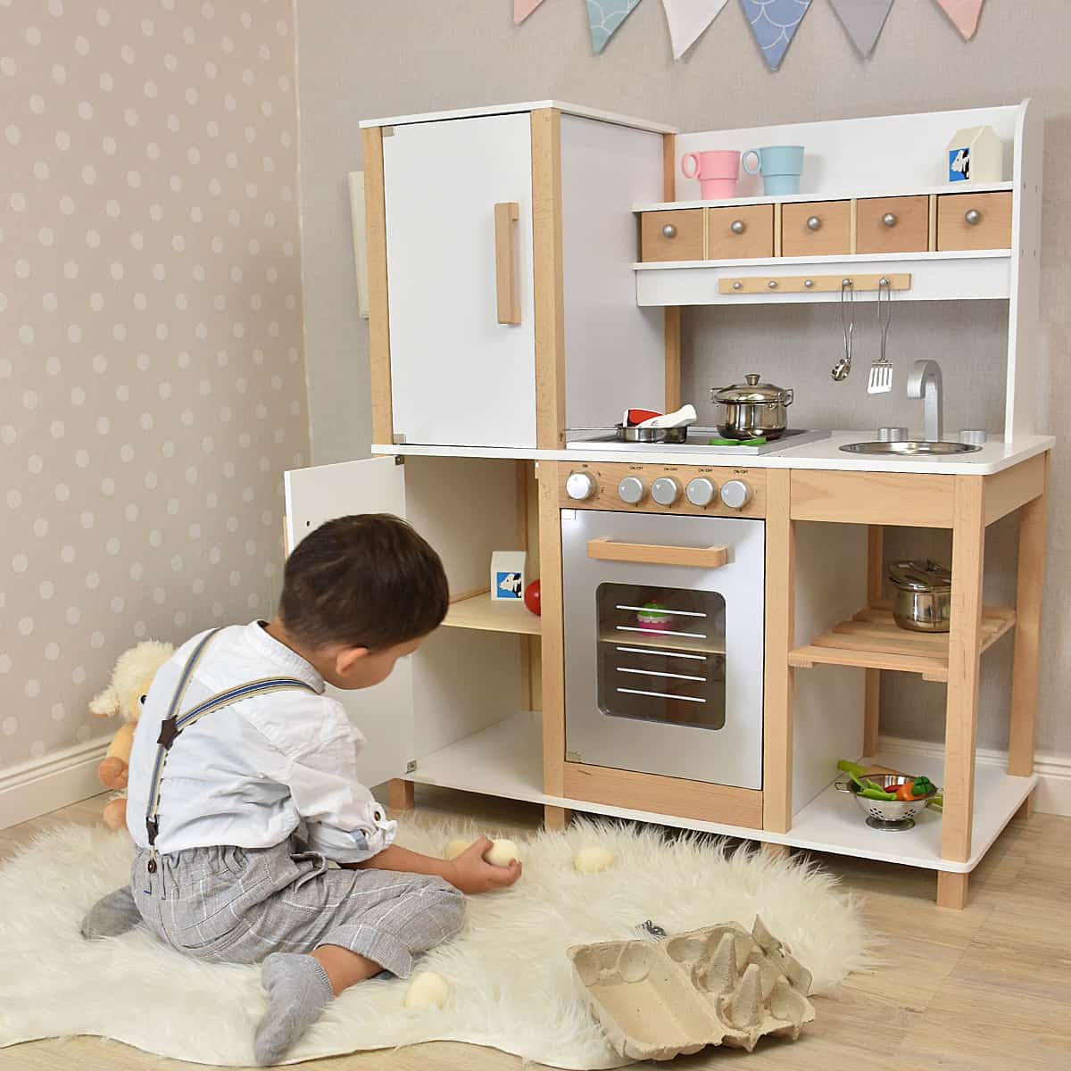 Kinderküche im eingerichteten Kinderzimmer mit Kind