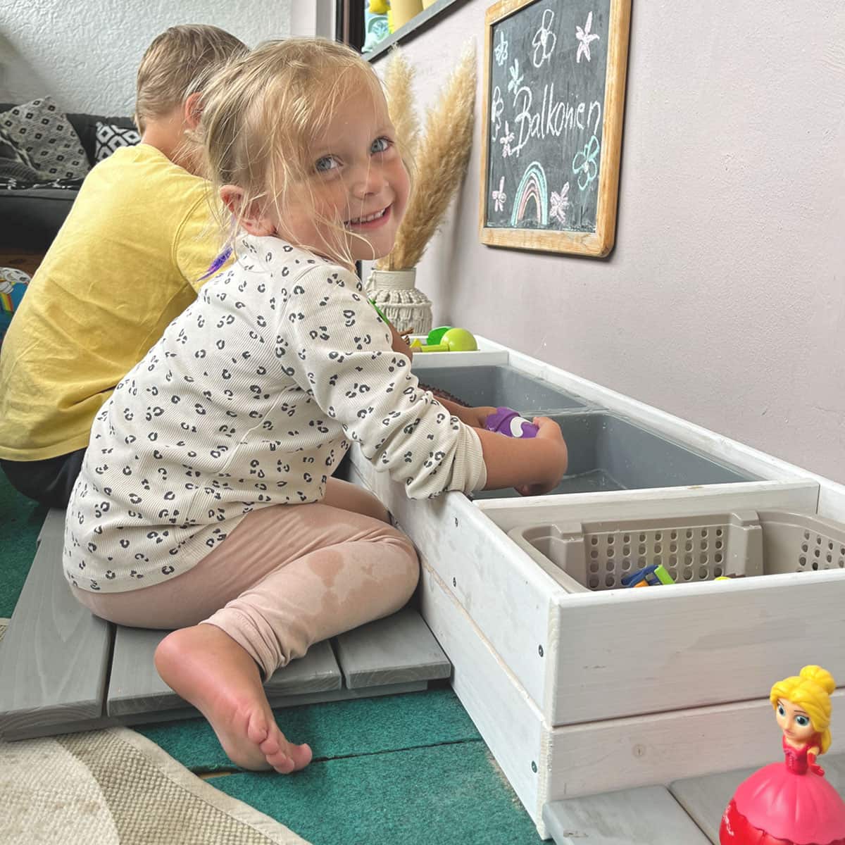 Sandkasten Kinder spielen mit Matschwannen