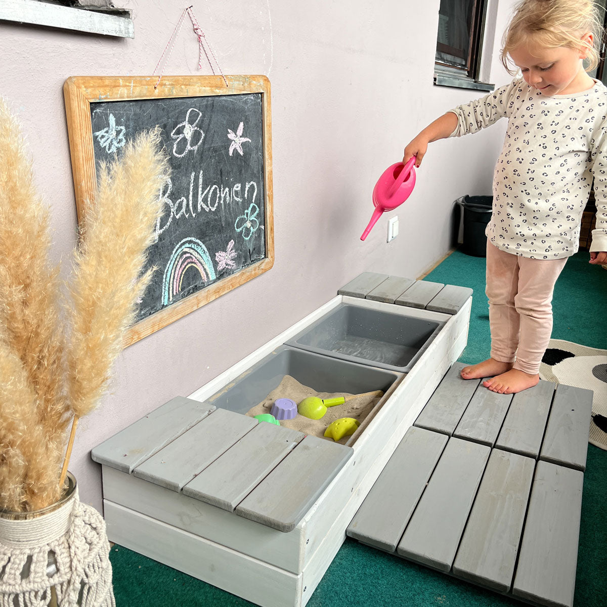 Sandkasten mit stehendem Kind